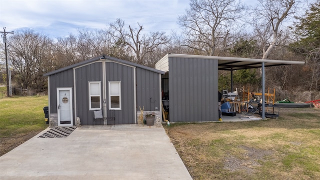 view of outdoor structure featuring a lawn and a carport