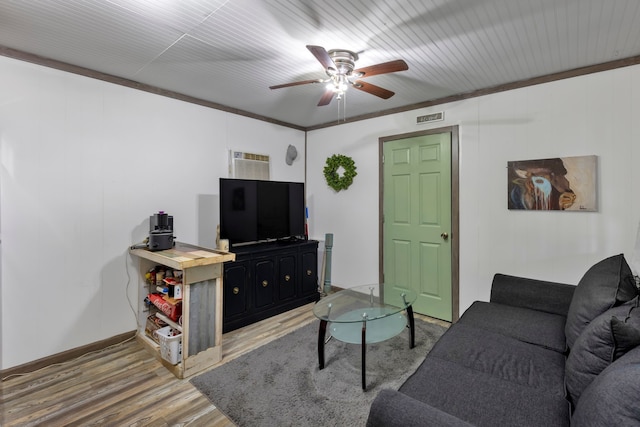 living room with wood-type flooring, ornamental molding, an AC wall unit, and ceiling fan