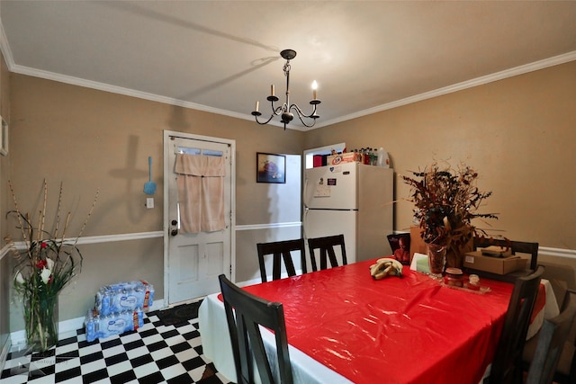 dining area with tile patterned floors, ornamental molding, and a notable chandelier