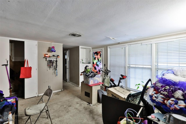interior space with baseboards, visible vents, light carpet, and a textured ceiling
