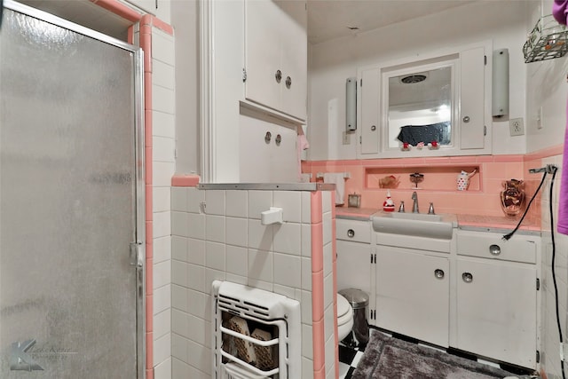 bathroom featuring toilet, an enclosed shower, tasteful backsplash, vanity, and tile walls