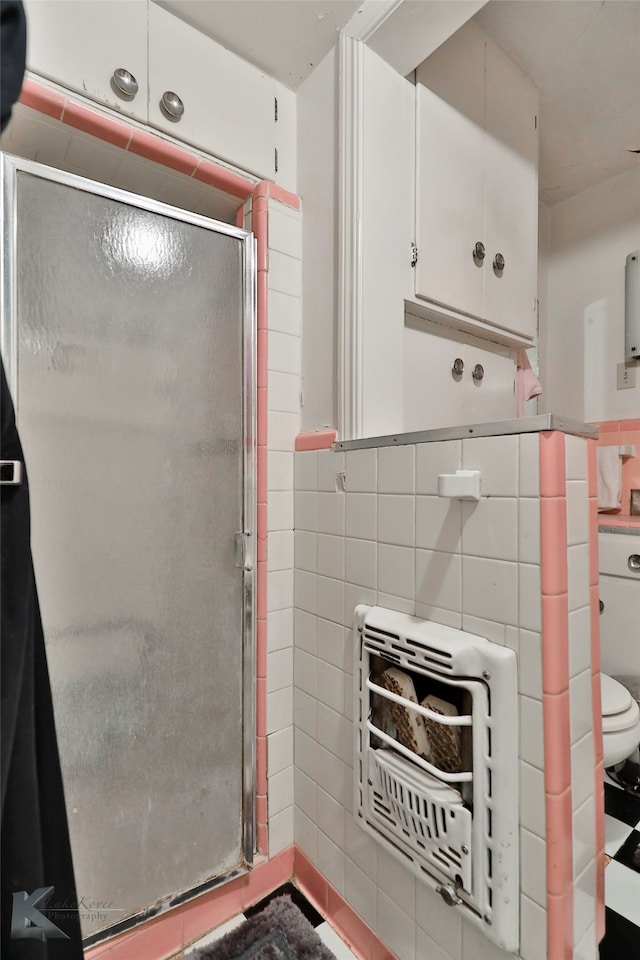 bathroom featuring tile walls, tile patterned floors, walk in shower, and toilet