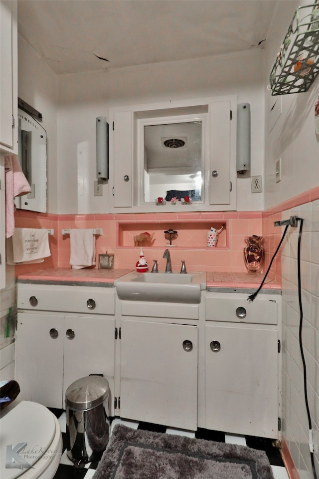 bathroom featuring tile walls, toilet, vanity, and tasteful backsplash