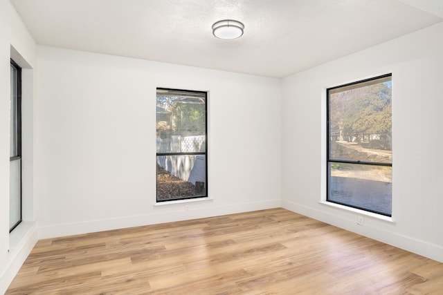 empty room featuring a textured ceiling and light hardwood / wood-style floors