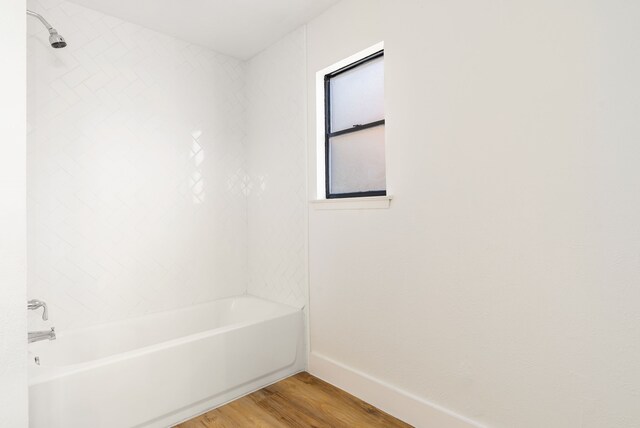 bathroom with wood-type flooring and tiled shower / bath combo