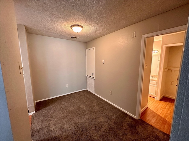 empty room featuring carpet and a textured ceiling