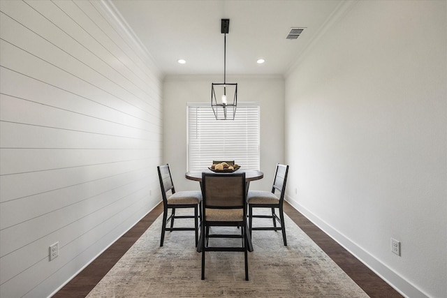 dining space with crown molding and dark wood-type flooring