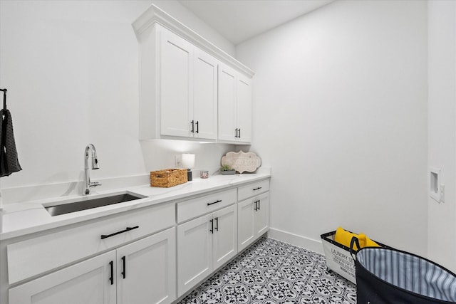 laundry area with sink, hookup for a washing machine, cabinets, and light tile patterned floors