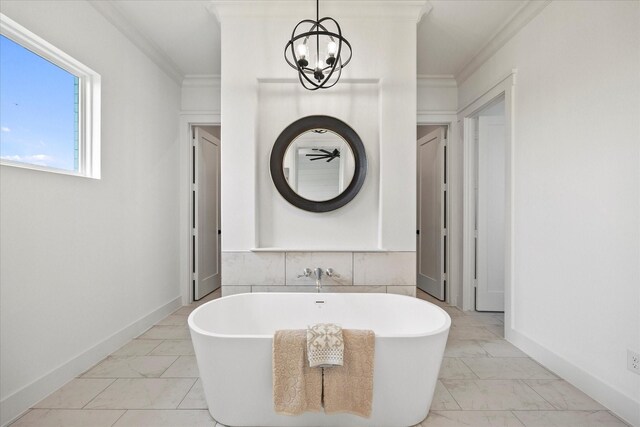 bathroom with an inviting chandelier, ornamental molding, a bathtub, and tile walls