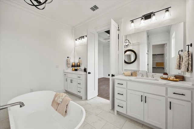 bathroom with vanity, crown molding, and a tub