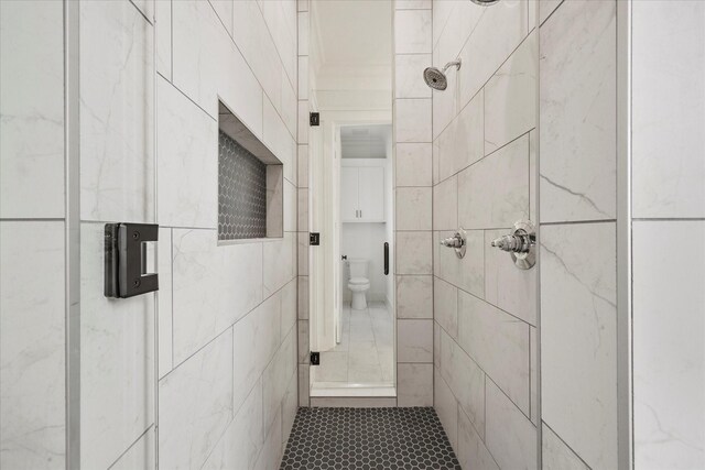 bathroom with toilet and tiled shower