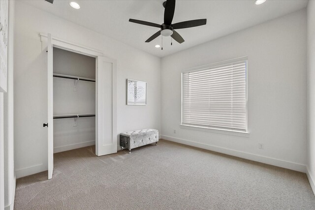 unfurnished bedroom with light carpet, a closet, and ceiling fan