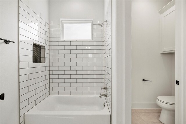 bathroom featuring tiled shower / bath, tile patterned floors, and toilet