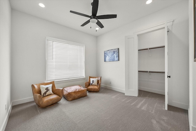 living area with carpet floors and ceiling fan