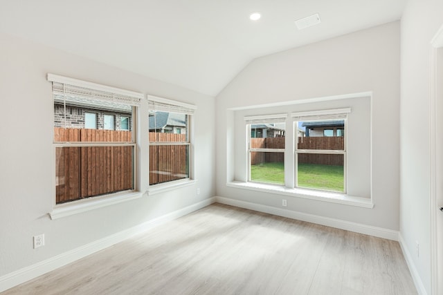 unfurnished room with lofted ceiling and light hardwood / wood-style flooring