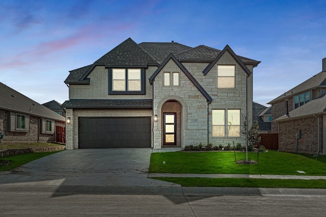 view of front of house featuring a garage and a yard