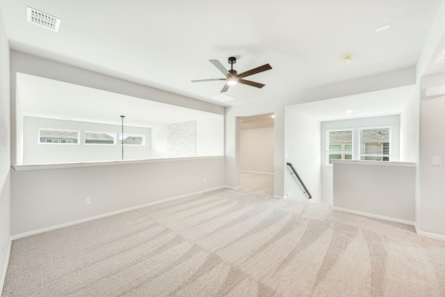 spare room featuring light colored carpet and ceiling fan