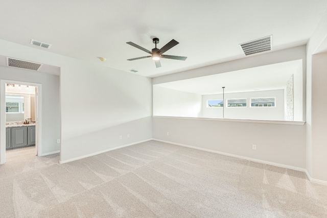 carpeted spare room with ceiling fan and a wealth of natural light