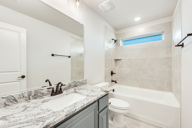 full bathroom featuring toilet, tiled shower / bath combo, and vanity