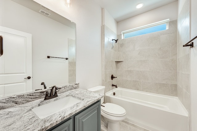 full bathroom with tiled shower / bath combo, large vanity, and toilet