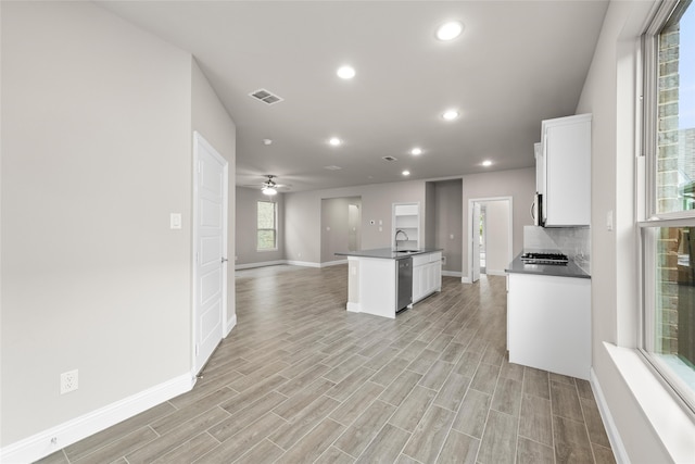 kitchen featuring tasteful backsplash, a healthy amount of sunlight, and dishwasher