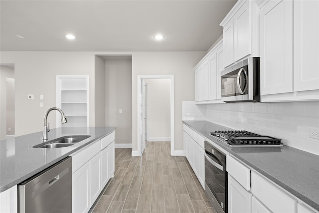 kitchen with backsplash, stainless steel appliances, light hardwood / wood-style floors, white cabinets, and sink