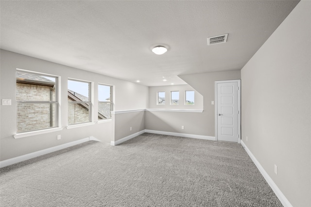 carpeted spare room with a textured ceiling