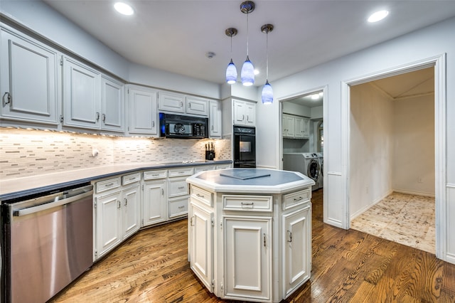 kitchen with a kitchen island, black appliances, hardwood / wood-style floors, pendant lighting, and tasteful backsplash