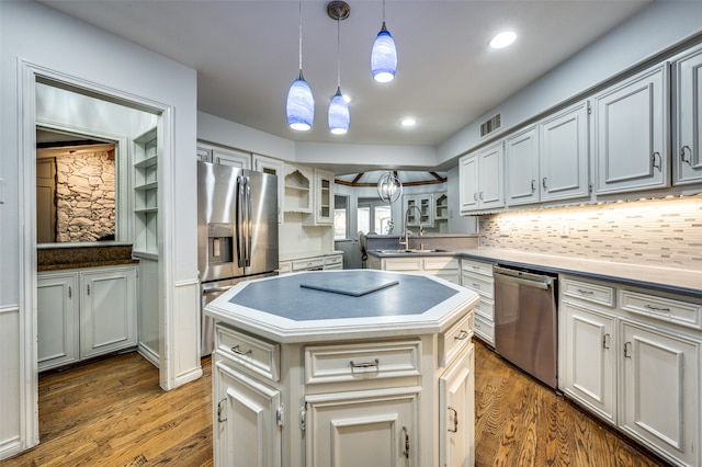 kitchen with sink, hardwood / wood-style floors, pendant lighting, and appliances with stainless steel finishes