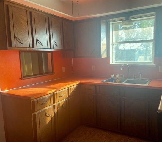 kitchen featuring a wealth of natural light, sink, dark tile patterned floors, and tasteful backsplash