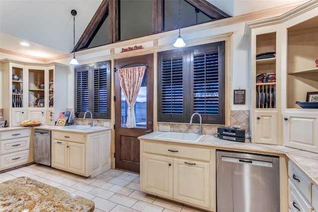 kitchen with cream cabinets, sink, stainless steel dishwasher, and decorative light fixtures