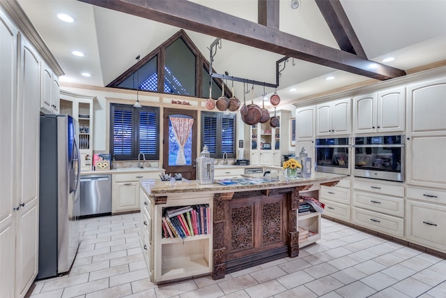 kitchen with light stone counters, a kitchen island, high vaulted ceiling, and appliances with stainless steel finishes