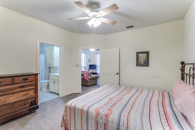 bedroom featuring ensuite bathroom, ceiling fan, and light carpet