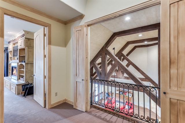 hallway with carpet flooring, vaulted ceiling with beams, and ornamental molding