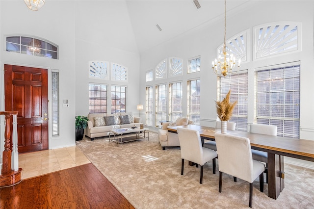 dining space featuring a notable chandelier, a high ceiling, and wood finished floors