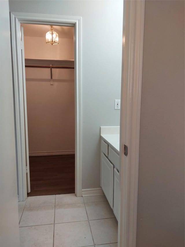 bathroom with vanity, tile patterned flooring, and a chandelier