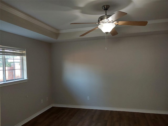 unfurnished room with dark wood-type flooring, ceiling fan, ornamental molding, and a raised ceiling