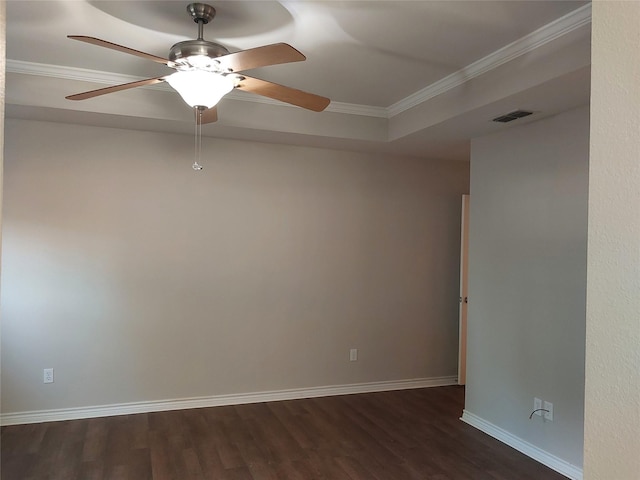 spare room featuring a raised ceiling, ceiling fan, dark hardwood / wood-style flooring, and crown molding