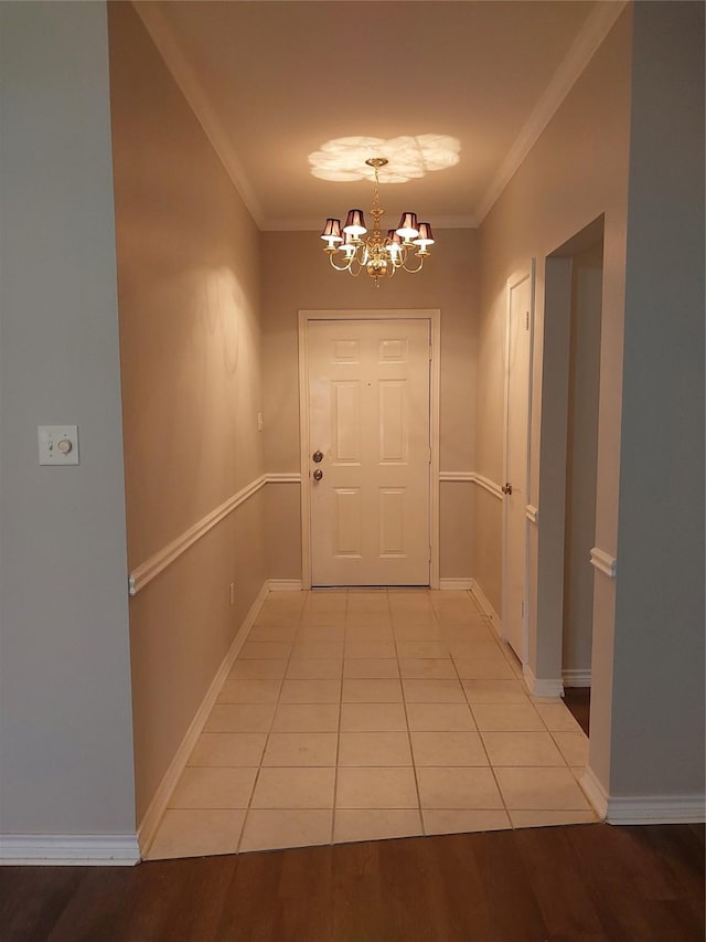 corridor with light tile patterned floors, a notable chandelier, and ornamental molding