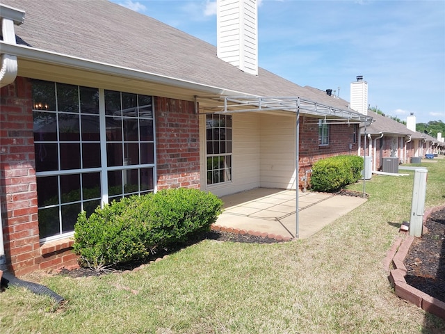 back of property with a patio area, a yard, and central air condition unit