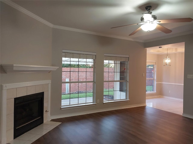 unfurnished living room featuring light hardwood / wood-style floors, ceiling fan with notable chandelier, crown molding, and a fireplace