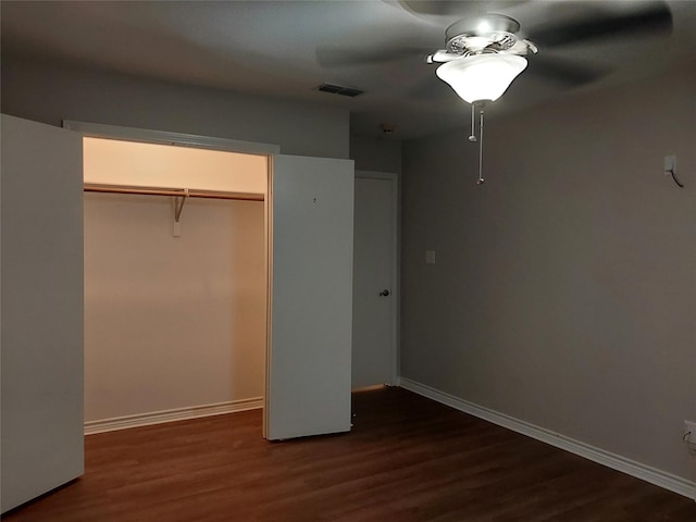 unfurnished bedroom featuring ceiling fan, dark hardwood / wood-style flooring, and a closet