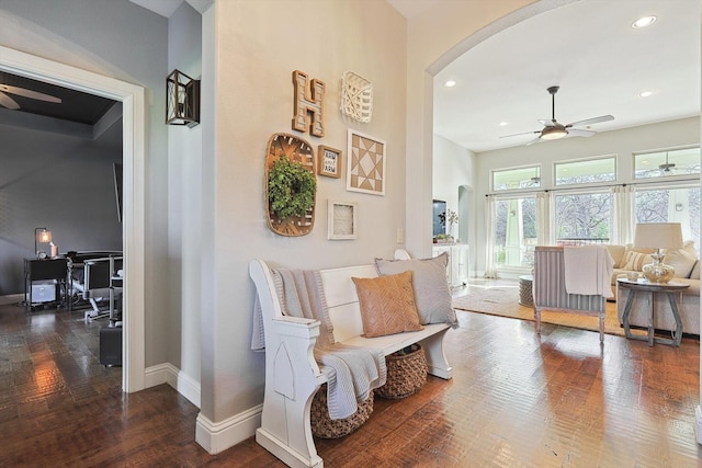 living area with ceiling fan and dark wood-type flooring