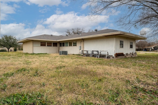 back of property featuring a yard and central AC unit