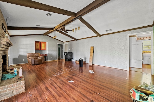 living room with wood-type flooring, a fireplace, lofted ceiling with beams, and ceiling fan