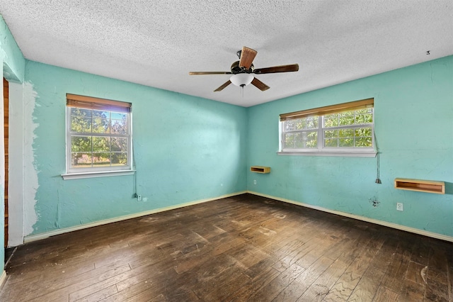 empty room with a textured ceiling, wood-type flooring, and a healthy amount of sunlight