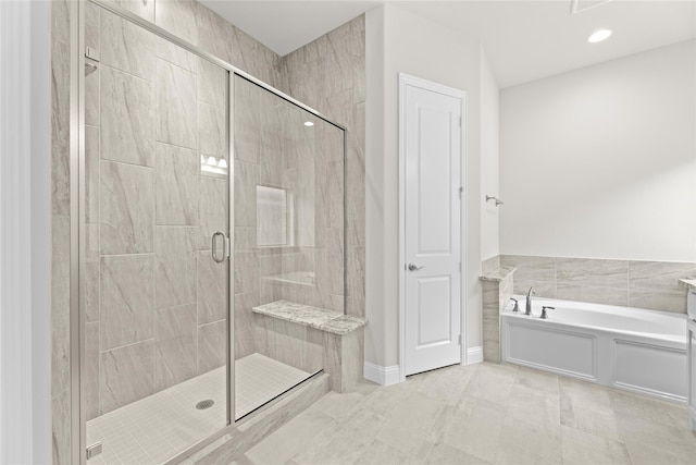 bathroom featuring plus walk in shower, tile patterned flooring, and tile walls