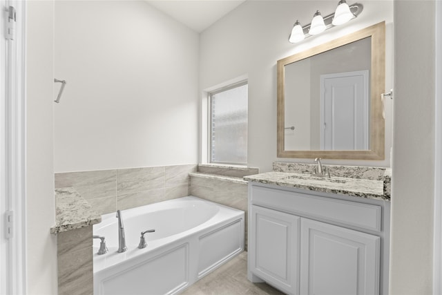 bathroom featuring tile patterned flooring, a bathing tub, and vanity