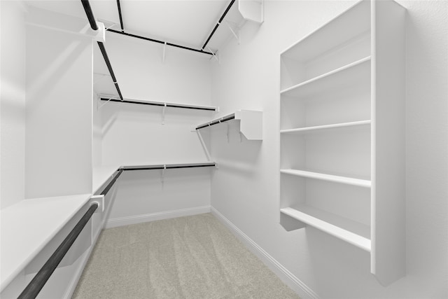 walk in closet featuring light carpet