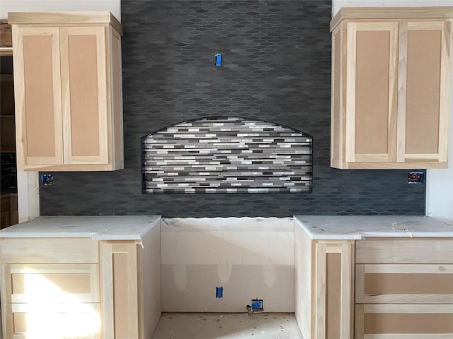 kitchen featuring light brown cabinets and tasteful backsplash